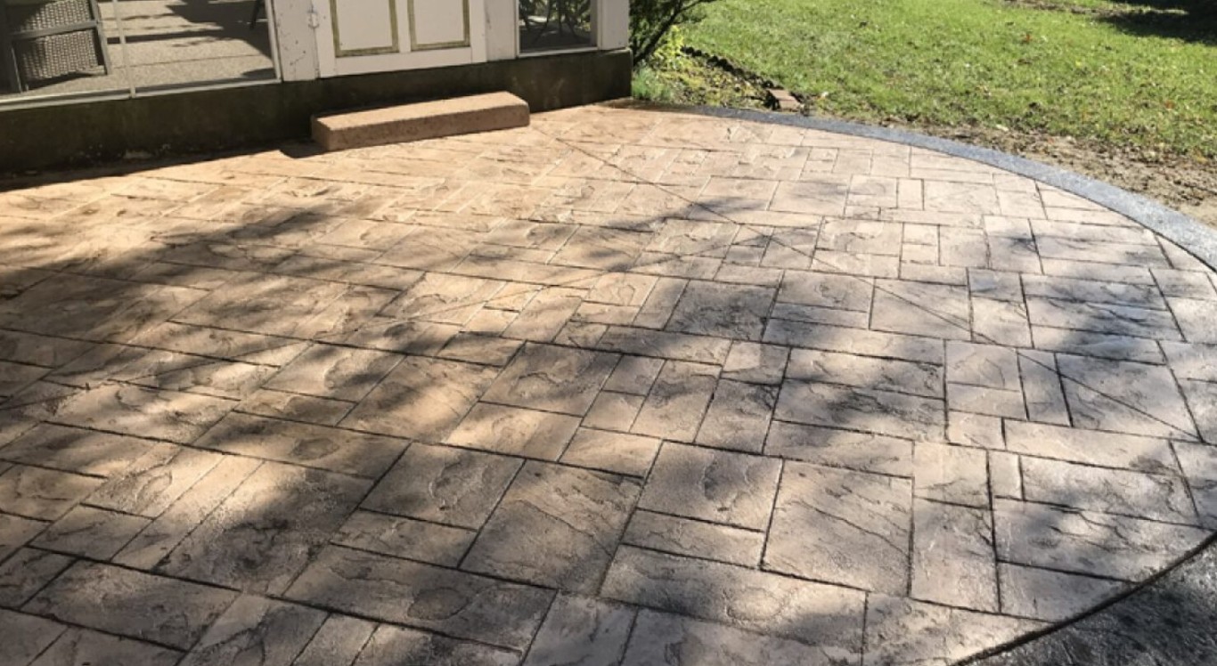 Stamped concrete patio installation with elegant stone pattern